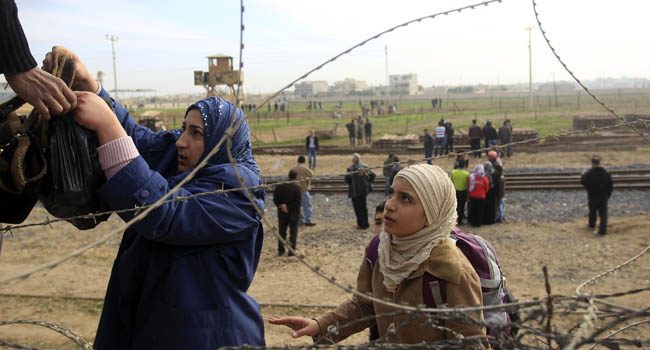 Syrians cross the border from the Syrian town of Ras al-Ain to the Turkish border town of Ceylanpinar after an air strike