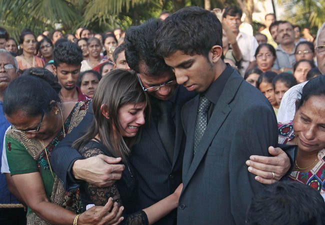 Jacintha Saldanha's widower Barboza and her children Lisha and Junal mourn during her funeral at a cemetery in Shirva