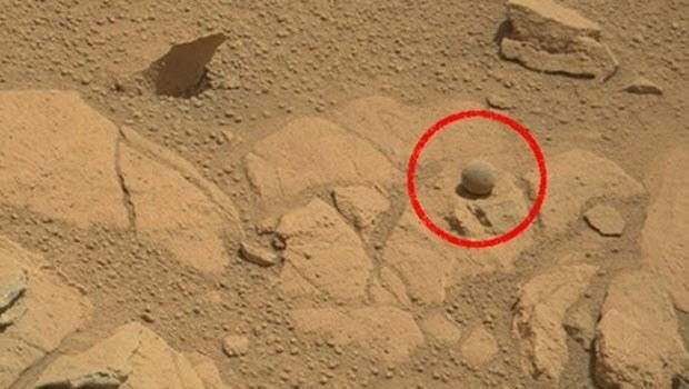 Discovery News sitesinde yayınlanan habere göre, Curiosity'nin çektiği fotoğraflar arasında düz bir kayanın yüzeyinde, mükemmel bir küre şeklindeki bir 'top' görülüyor. Biraz tozlu olmakla birlikte, aslında çevresindeki diğer kayalardan farklı bir rengi olduğu da görülebiliyor.