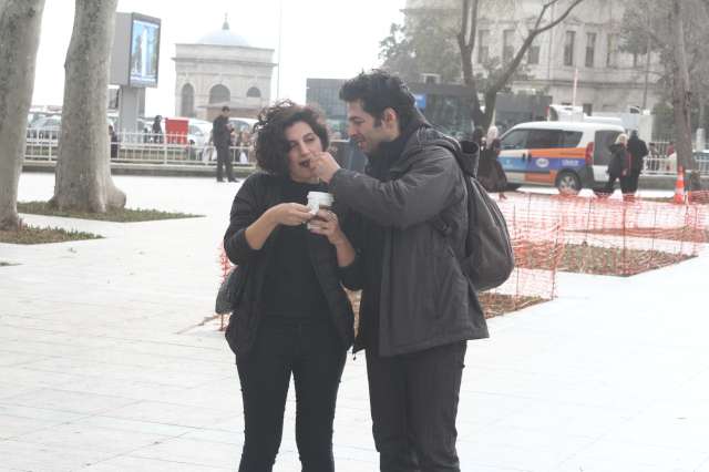 Yakışıklı oyuncu, yürürken bir ara çantasında tatlı çıkartıp bayan arkadaşına yedirmeye başladı. Tam o sırada bayan arkadaşı objektiflere yakalandığını fark edince Mert Fırat’tan uzaklaşmaya çalıştı.