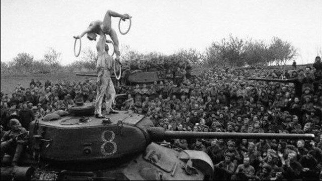 Sovyet askerleri Berlin dışında bir alanda dinlenirken tank üzerinde cambazlar şov sergiliyor 1945