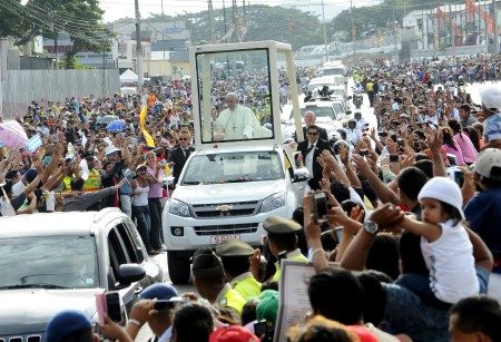Pope Francis waves to faithful from a popemobile while driving through Guayaquil