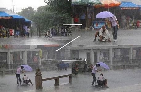 Evsiz ve yürüyecek hali olmayan bu adamı, sağanak yağmurdan koruyan bu kadın.