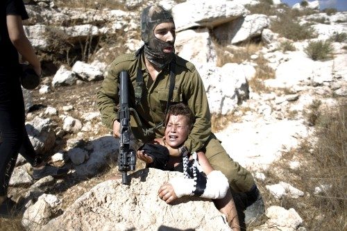 Batı Şeria'da Ramallah'ın batısındaki Nebi Salih bölgesinde toplanan protestoculara müdahale eden İsrail askerlerinden biri, kolu sargılı bir Filistinli çocuğu gözaltına almak istedi.