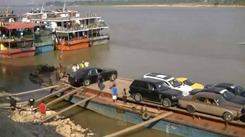 Otomobiller, kara ile deniz aracının arasına koyulan tahtaların üzerinden geçiriliyor.