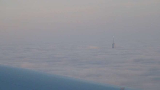 Saat 16:00 - New York gözüktü. Bulutlar üzerinde One World Trade Center