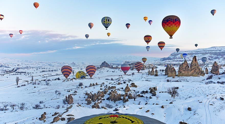 Kapadokya'nın eşsiz kış manzarasını gökyüzünden keşfetmek isteyen turistler, doğa harikası peribacalarını ve bölgenin doğal güzelliklerini kuşbakışı izliyor.