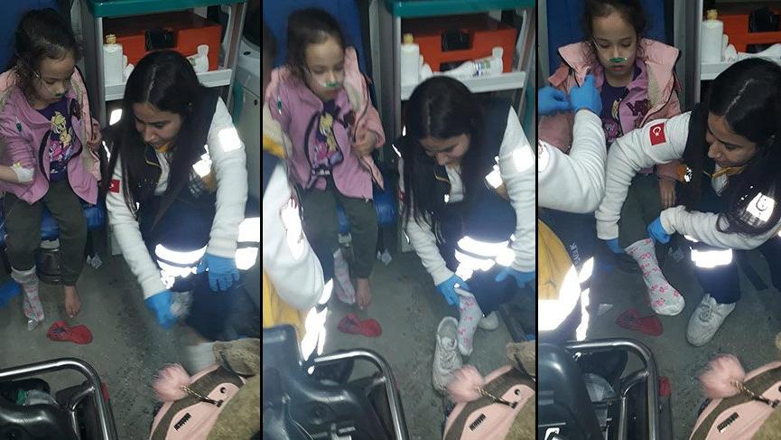 Sağlık görevlisi çorabı olmayan küçük kıza kendi çoraplarını giydirdi