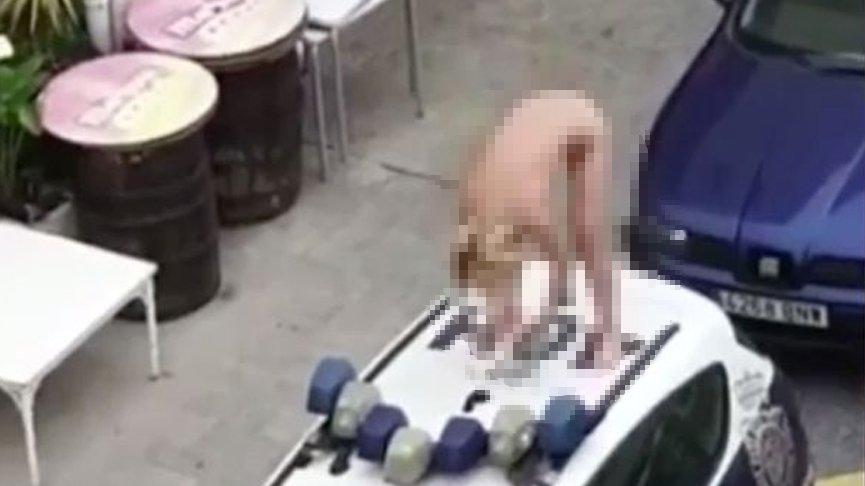 Polis arabasının üzerine çıkan kadın bir anda soyundu!