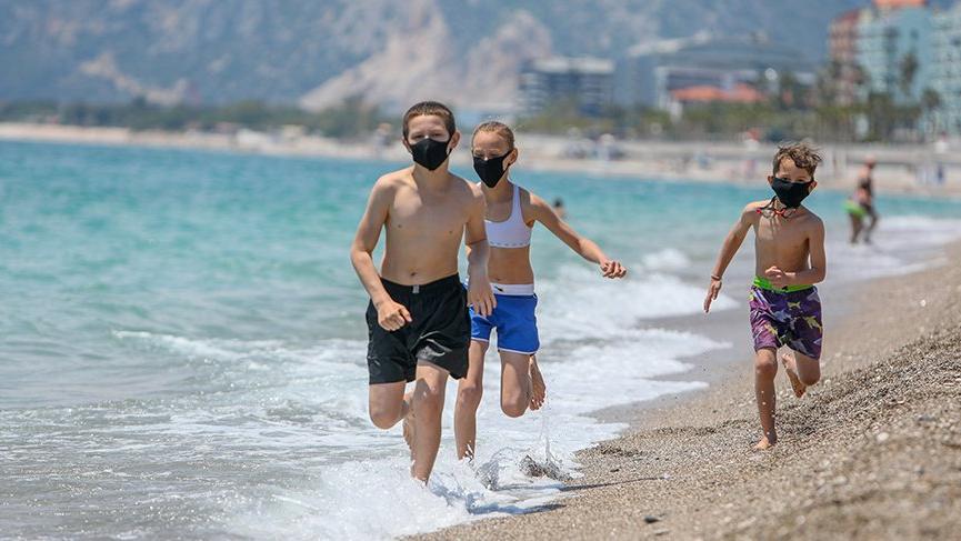Antalya’da tatilciler maskeyle güneşlendi