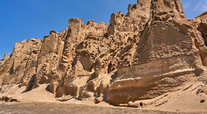 Santorini'deki çoğu plaj gibi nispeten sığ sularının yanı sıra, koyu volkanik kumu ve çakıl taşları bu uzun pajın diğer belirgin özellikleri.